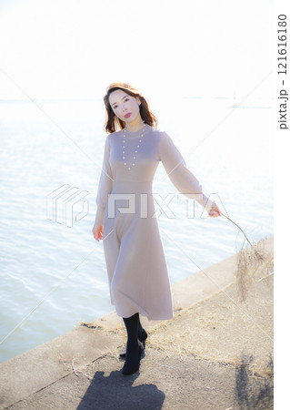 秋空の晴天のもと水辺に立つ美人ミセス。 秋空の晴天のもと水辺に立つ美人ミセス。 121616180