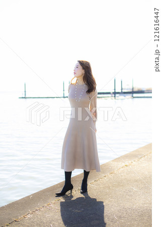 秋空の晴天のもと水辺に立つ美人ミセス。 秋空の晴天のもと水辺に立つ美人ミセス。 121616447