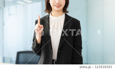 人差し指を立てて案内する若い女性・ビジネスウーマン 人差し指を立てて案内する若い女性・ビジネスウーマン 121616581