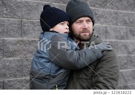 Father and son walking down on sidewalk together. Portrait of a handsome middle-aged man with toddler boy in the urban street. Dad and his child sitting on a bench in city park. City life. Family 121618222