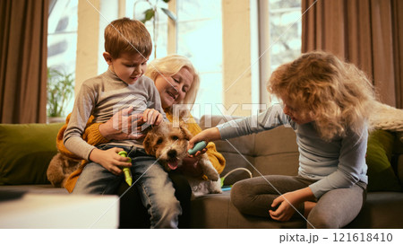 Family scene where grandmother supports playful medical role-play, children practice teamwork, learn compassion and knowledge about health and well-being. 121618410
