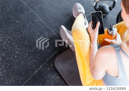 fit woman using app on phone in gym fit woman using app on phone in gym 121618899