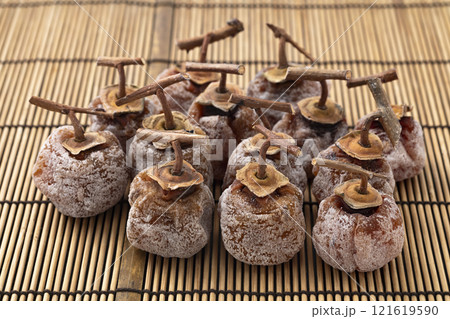 竹マット背景のへた付きの干し柿 121619590