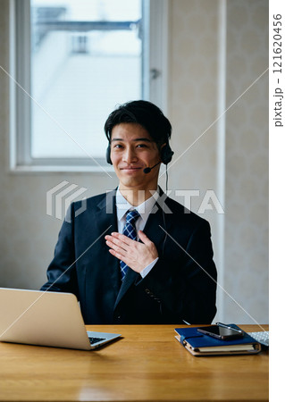胸に手を当てる20代の若い男性 121620456