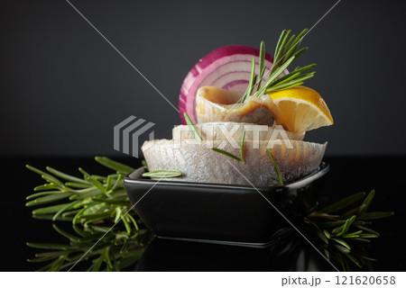 Herring fillet in oil with lemon, red onion, and rosemary. Herring fillet in oil with lemon, red onion, and rosemary. 121620658
