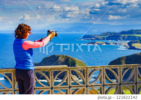 Tourist with camera on Asturias coast, Spain 121622142