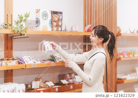 お土産を選ぶ若い女性【撮影協力・新潟甘味 premium WAGASHI 和NAGOMI】 お土産を選ぶ若い女性【撮影協力・新潟甘味 premium WAGASHI 和NAGOMI】 121622329