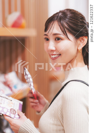 お土産を選ぶ若い女性【撮影協力・新潟甘味　premium WAGASHI 和NAGOMI】 121622337