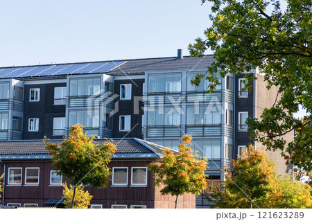 Residential building with new roof and solar panels. Real estate investment. Expensive housing. 121623289