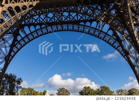 The Eiffel Tower is beautifully located under an archway, set against a clear blue sky 121623438