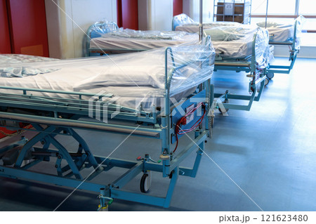 Clean hospital beds covered with film, ready for new patients. Clean hospital beds covered with film, ready for new patients. 121623480