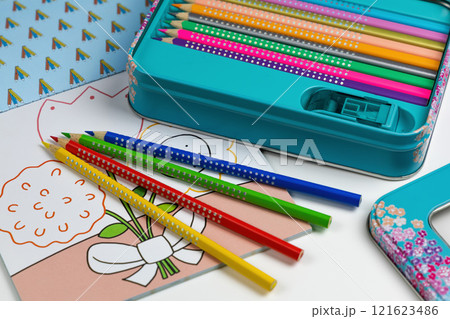 Colored pencils for drawing various colors and coloring book for children. 121623486