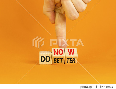 Do better and now symbol. Concept words Do better Do now on wooden block. Beautiful orange table orange background. Businessman hand. Business do better and now concept. Copy space. 121624603
