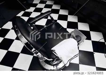 Barber chair in a stylish salon with black and white flooring design 121624803