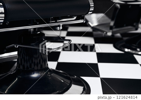 Stylish black-and-white barber shop with checkered floor and chairs 121624814