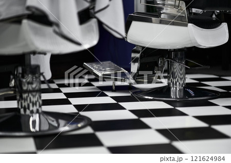 Stylish barbershop interior with modern design elements and checkered flooring Stylish barbershop interior with modern design elements and checkered flooring 121624984