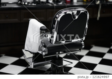 Classic barber chair in a vintage barbershop setting with checkered floor Classic barber chair in a vintage barbershop setting with checkered floor 121624997