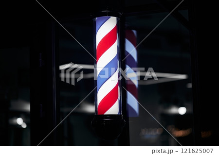 Barber pole with red, white, and blue stripes illuminated at night Barber pole with red, white, and blue stripes illuminated at night 121625007