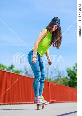 Teen girl skater riding skateboard on street. 121625688