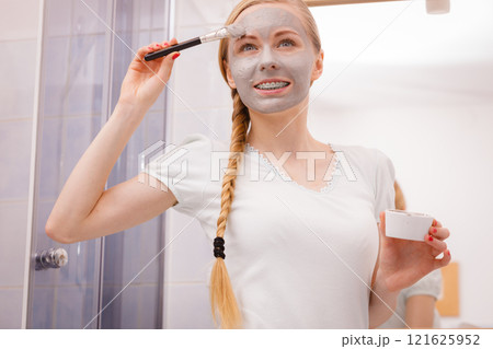 Woman with grey clay mud mask on her face 121625952