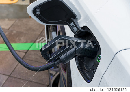 An electric vehicle connects to a sleek charging station, showcasing advanced technology for energy efficiency and eco-friendly transportation options 121626123