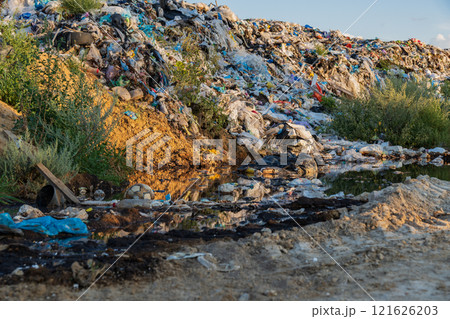 Mountains of garbage stretch across the landscape, casting a shadow on the surrounding ecosystem Mountains of garbage stretch across the landscape, casting a shadow on the surrounding ecosystem 121626203