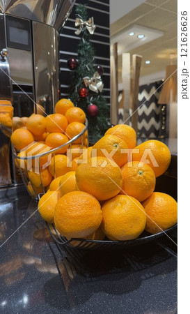 Basket of Fresh Oranges Displayed on a Countertop Near Festive Decorations 121626626
