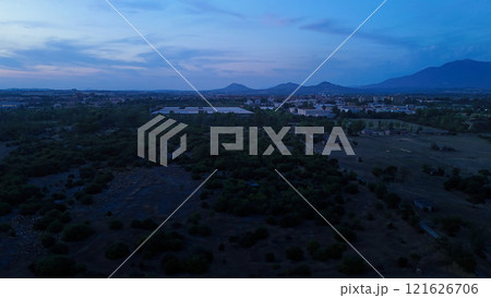 Cityscape turning on lights at dusk with mountains in background Cityscape turning on lights at dusk with mountains in background 121626706