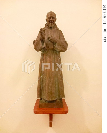 Statue of a blessing monk in a church 121628314