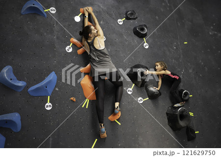 Determined mother and daughter climbing artificial 121629750