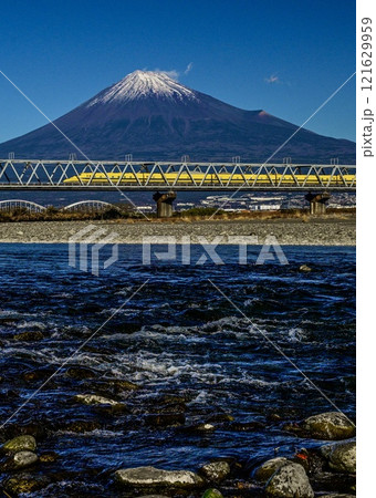 疾走するドクターイエロー 富士川の急流と富士山に挟まれての写真素材