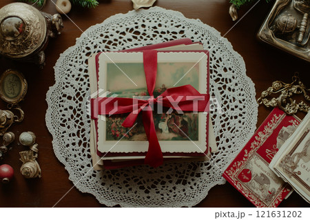 Elegant collection of vintage postcards tied with a red ribbon on a lace doily 121631202