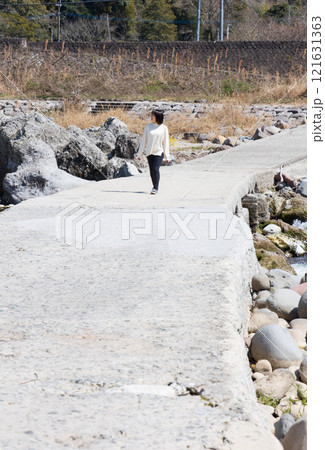 犬石・犬走りの景にある沈下橋を歩く女性 犬石・犬走りの景にある沈下橋を歩く女性 121631363