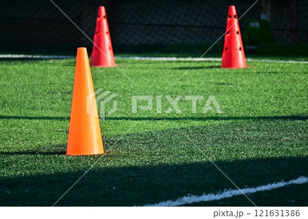 artificial green grass soccer field with orange training cones 121631386