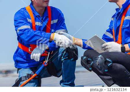 Technicians installing and inspecting standards solar panels on roof industrial factory. Shake hand work success experience. Electrical energy obtained from nature sunlight clean renewable energy. 121632134