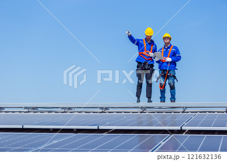 Technicians installing and inspecting standards solar panels on roof industrial factory. Shake hand work success experience. Electrical energy obtained from nature sunlight clean renewable energy. 121632136