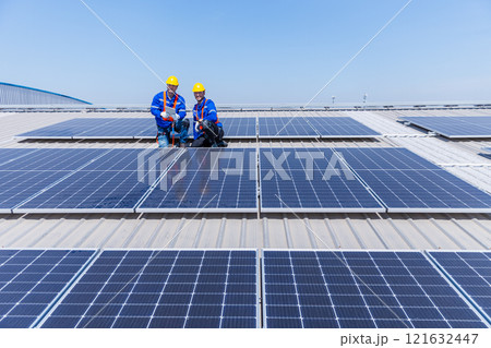 Technicians are installing and inspecting standards of solar panels on roof of an industrial factory. Electrical energy obtained from nature sunlight clean renewable energy. Technicians are installing and inspecting standards of solar panels on roof of an industrial factory. Electrical energy obtained from nature sunlight clean renewable energy. 121632447