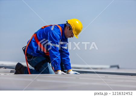 Technicians are installing and inspecting standards of solar panels on roof of an industrial factory. Electrical energy obtained from nature sunlight clean renewable energy. 121632452