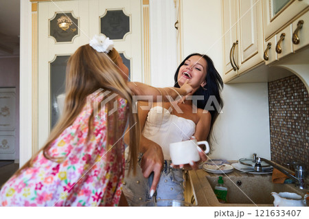 Joyful Mother and Daughter Baking Together in a Cheerful Kitchen During Afternoon Hours Joyful Mother and Daughter Baking Together in a Cheerful Kitchen During Afternoon Hours 121633407