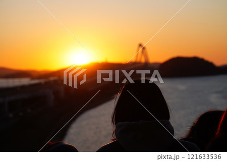 Silhouette of young woman watching sunset on the bridge in winter 121633536
