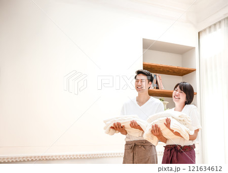 洗濯物を運びながら笑顔で話をするカップル 洗濯物を運びながら笑顔で話をするカップル 121634612