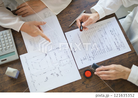 不動産の契約を結ぶ女性2人の手元 121635352