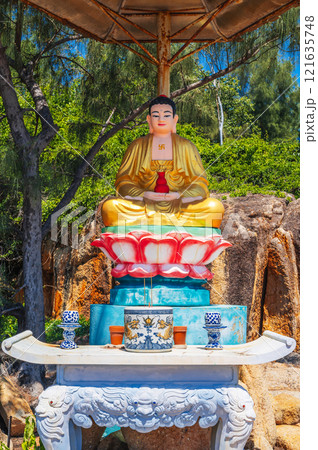An altar with a sitting Buddha on the territory of a Buddhist temple in Asia. An altar with a sitting Buddha on the territory of a Buddhist temple in Asia. 121635748