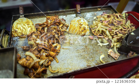 Freshly grilled barbecue squid on skewers displayed at an Asian street food market showcasing vibrant culinary traditions 121636356