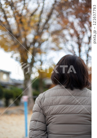 公園に座ってボーっとしている中高年女性の後ろ姿 公園に座ってボーっとしている中高年女性の後ろ姿 121637763