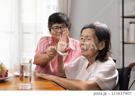 Senior asian woman bored with food. Senior asian woman bored with food. 121637907