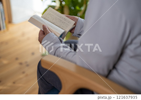 リビングルームのソファに座って読書している中高年女性 121637935