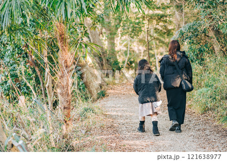 冬の森の中を歩くお母さんと子供 121638977