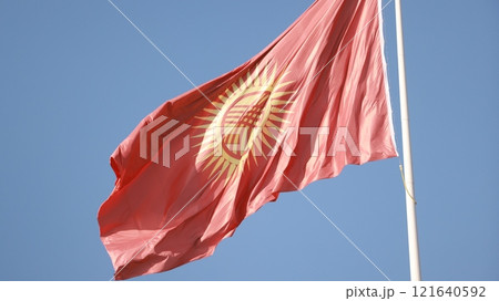 Kyrgyzstan flag is waving in Ala-Too Square against the blue sky 121640592