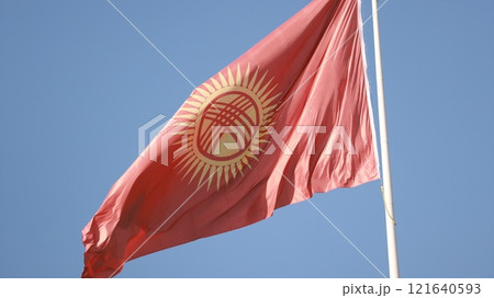 Kyrgyzstan flag is waving in Ala-Too Square against the blue sky 121640593